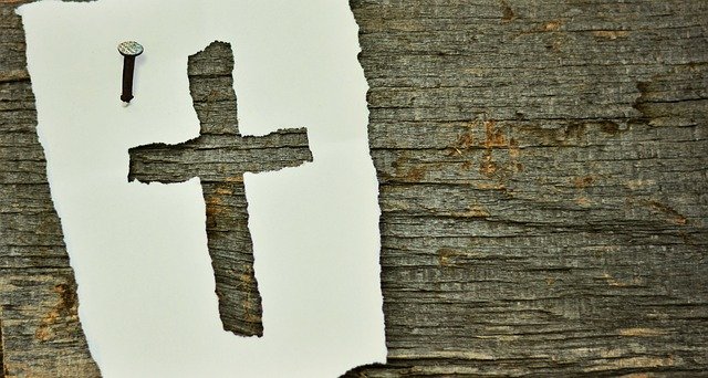 pic of rough cut cross in parchment nailed to weathered wood