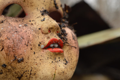 doll face soiled with garden dirt